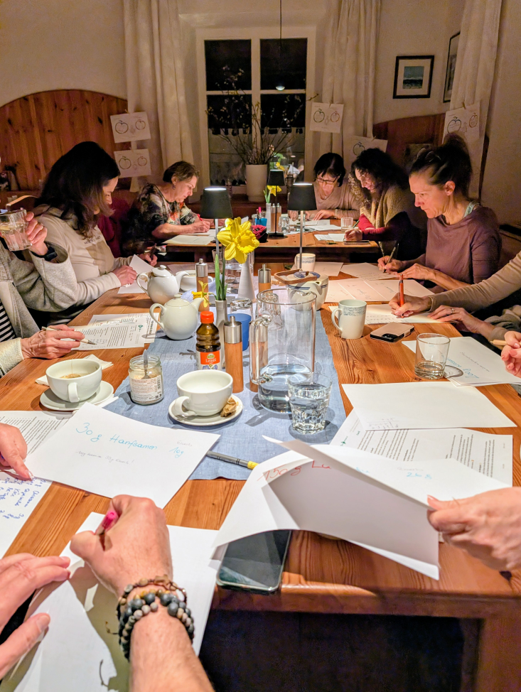 Teilnehmer sitzen konzentriert mit den Unterlagen am Tisch und schreiben.