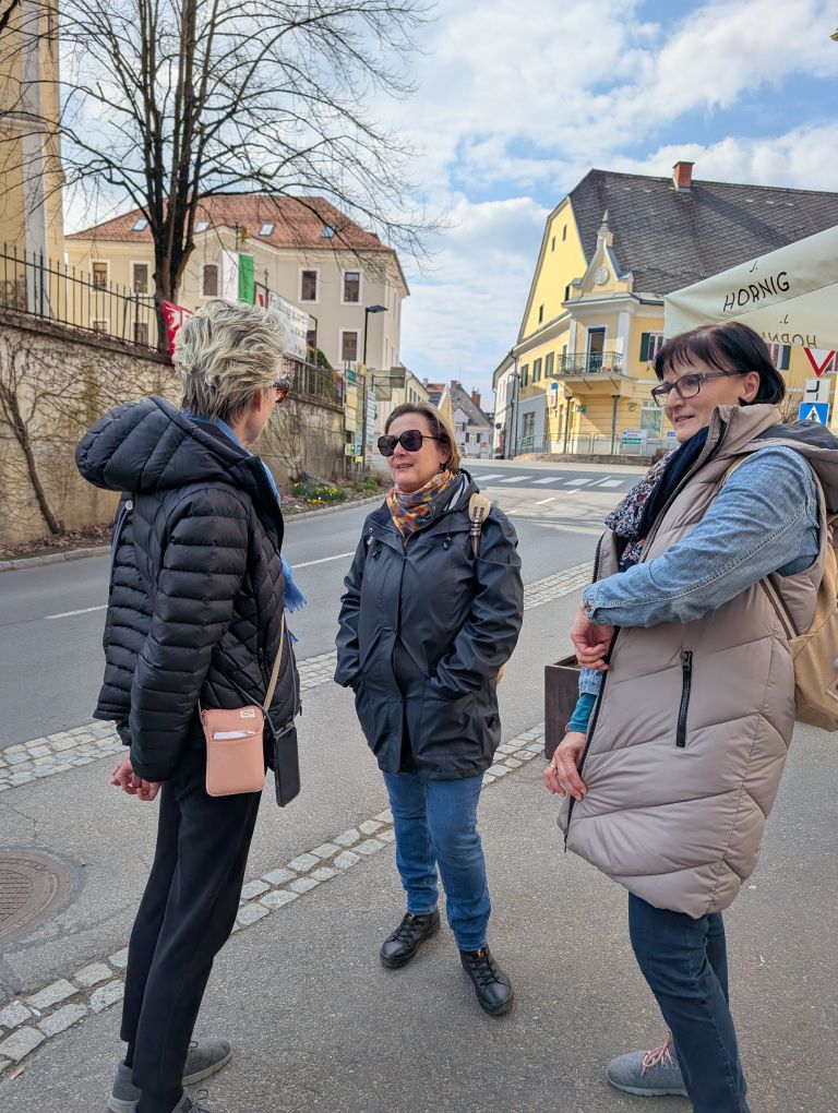 3 Frauen tratschend vor dem Geschäft