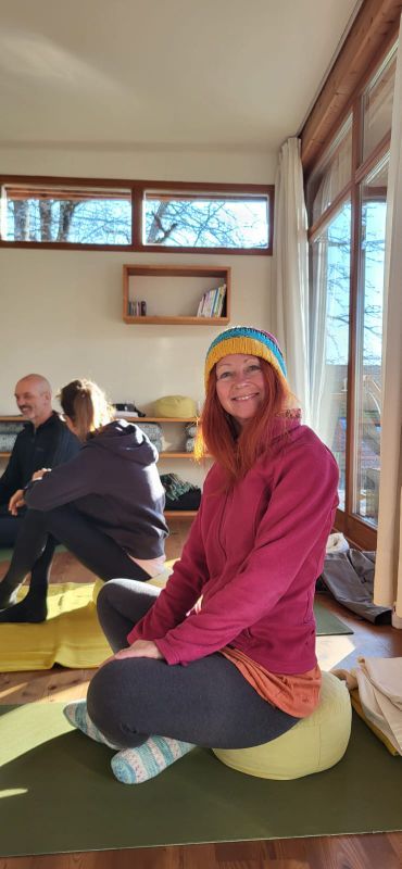 Karin mit Haube auf der Yogamatte