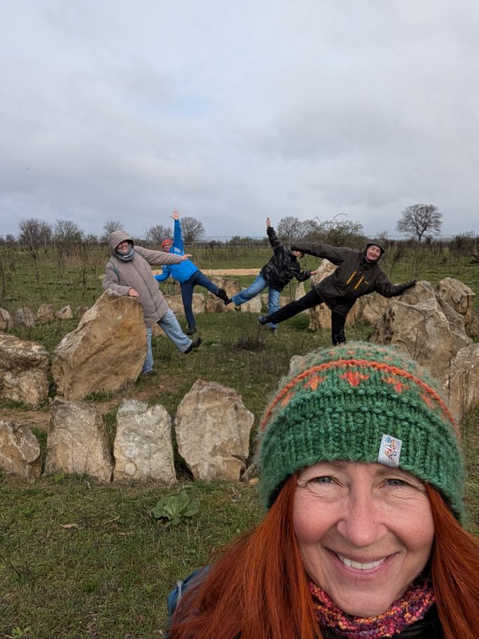 4 Menschen in einem Kreis aus großen Steinen, Karin im Vordergrund