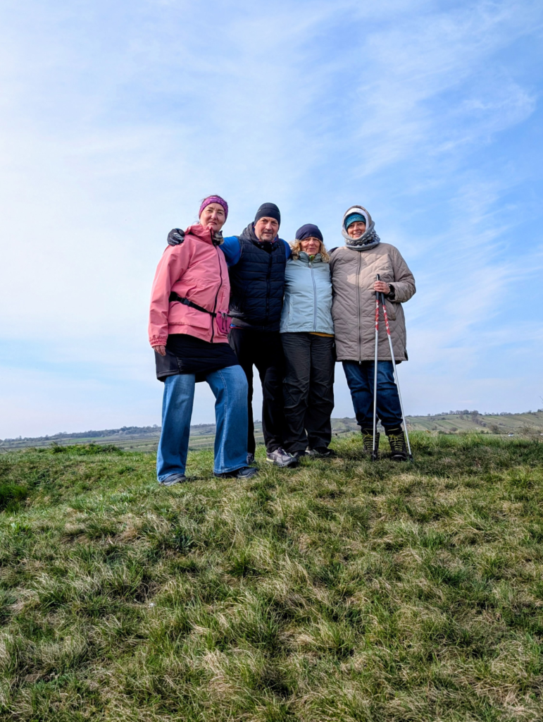 4 Teilnehmer nebeneinander auf einer Wiese. Im Hintergrund blauer Himmel