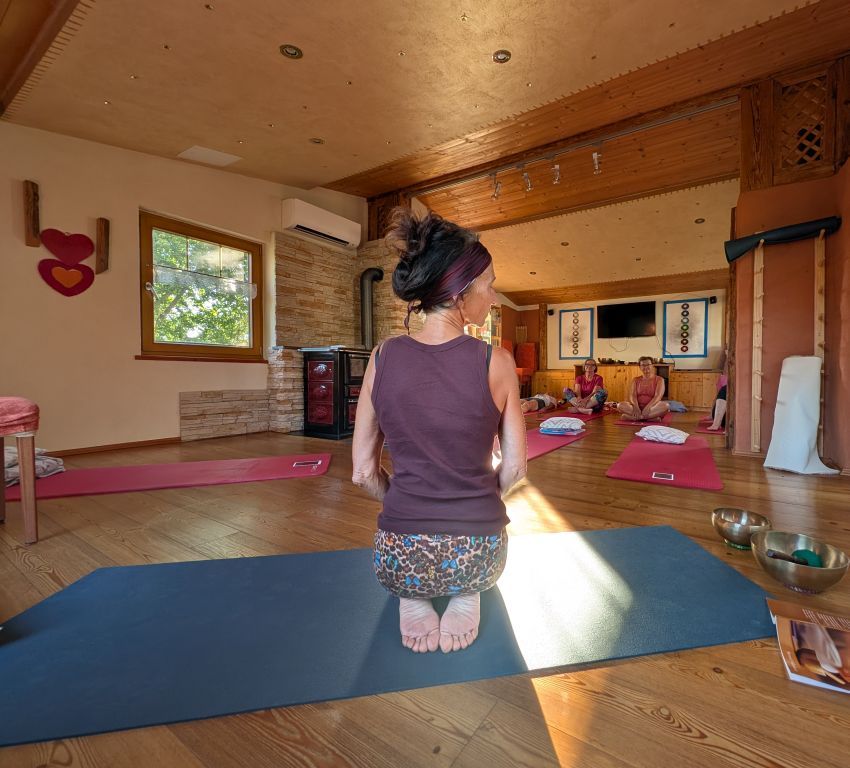 Claudia von hinten, knieend auf ihrer Yogamatte