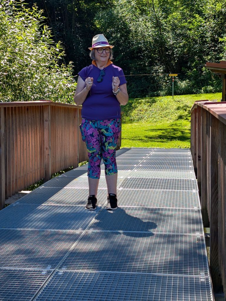Frau mit Wünschelruten auf einer Brücke