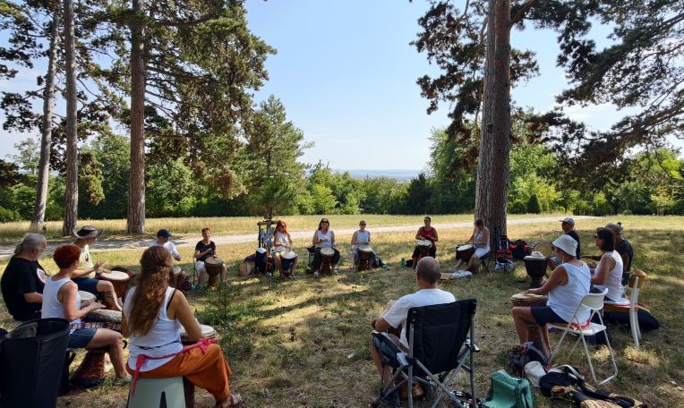 Gruppenbild - Trommelkreis unter schattigen Föhren