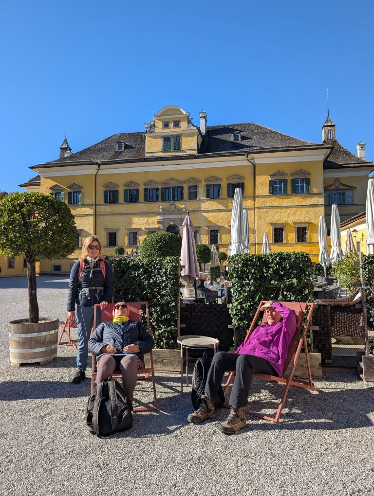 3 Teilnehmerinnen in Liegestühlen vor dem Schlossgebäude