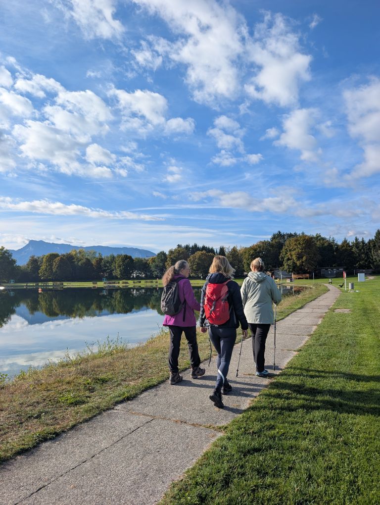 Drei Teilnehmerinnen von hinten, spazierend entlang des Seeufers